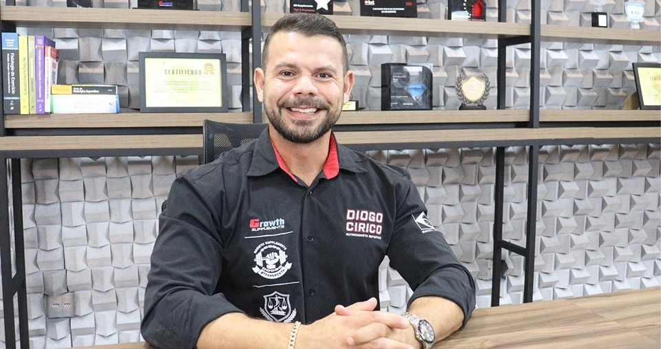 Diogo Círico - Nutricionista Esportivo Growth Supplements sentado dentro de uma sala com as mão em cima da mesa