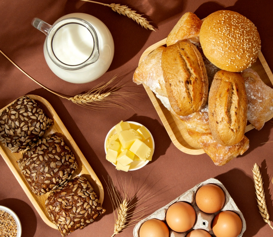 Mesa posta com pães, queijo, ovos e leite