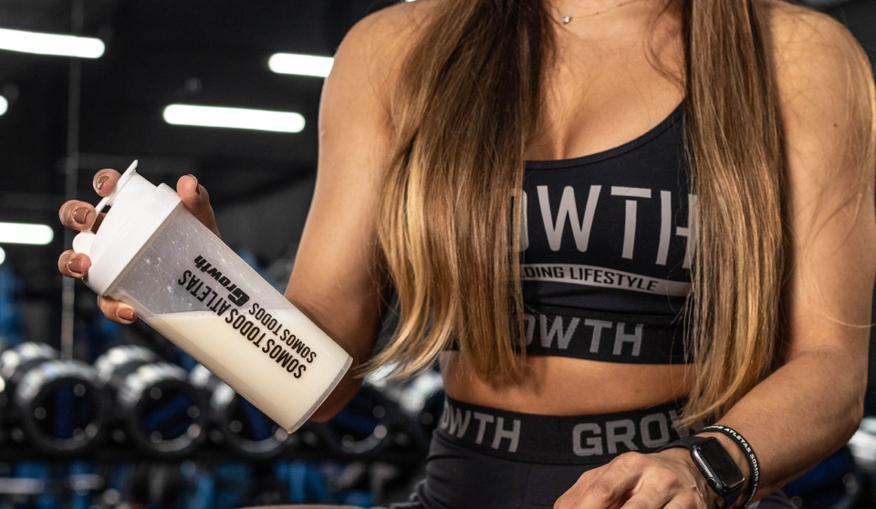 Atleta Growth Supplements com uma coqueteleira na mão