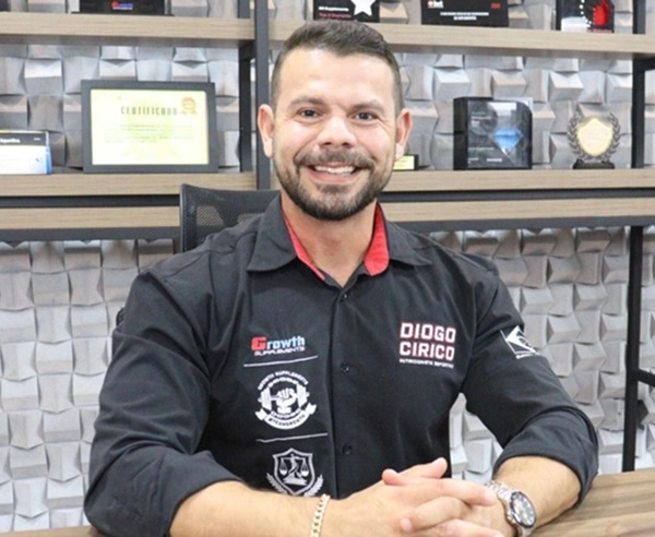 Diogo Círico - Nutricionista Esportivo Growth Supplements sentado dentro de uma sala com as mão em cima da mesa