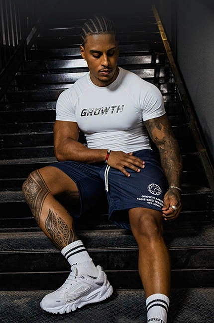 Atleta Growth Supplements, com Macaquinho da Marca e com as mãos levantadas no armário