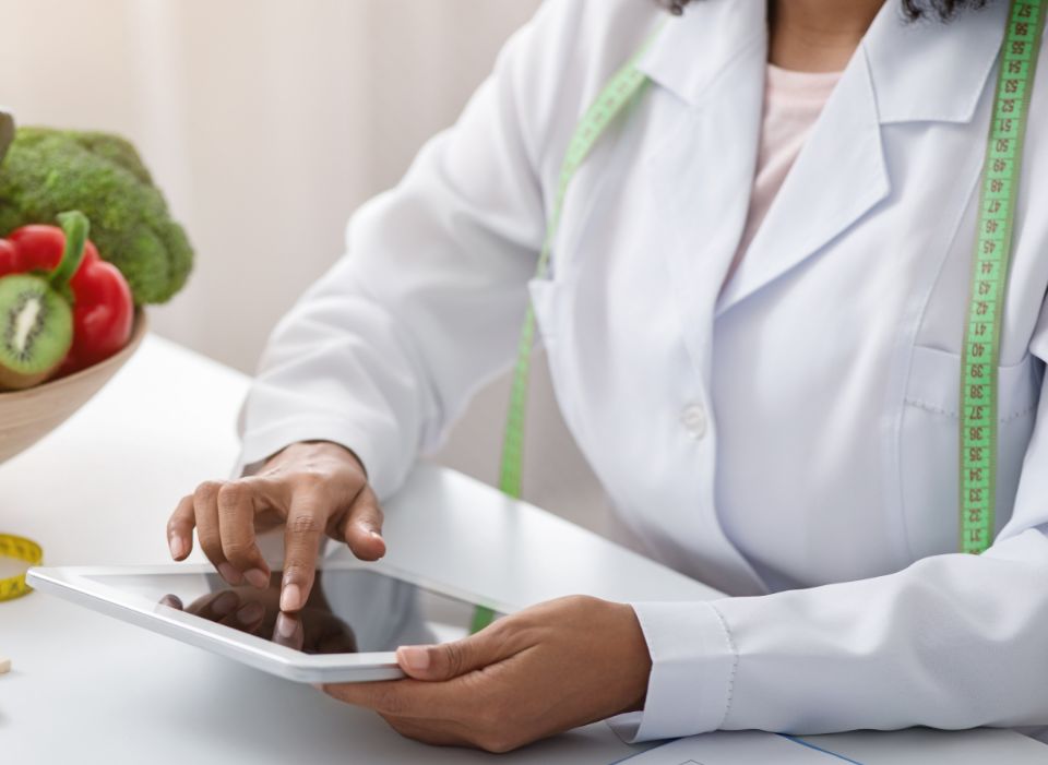 Nutricionista sentada com um tablet na mão