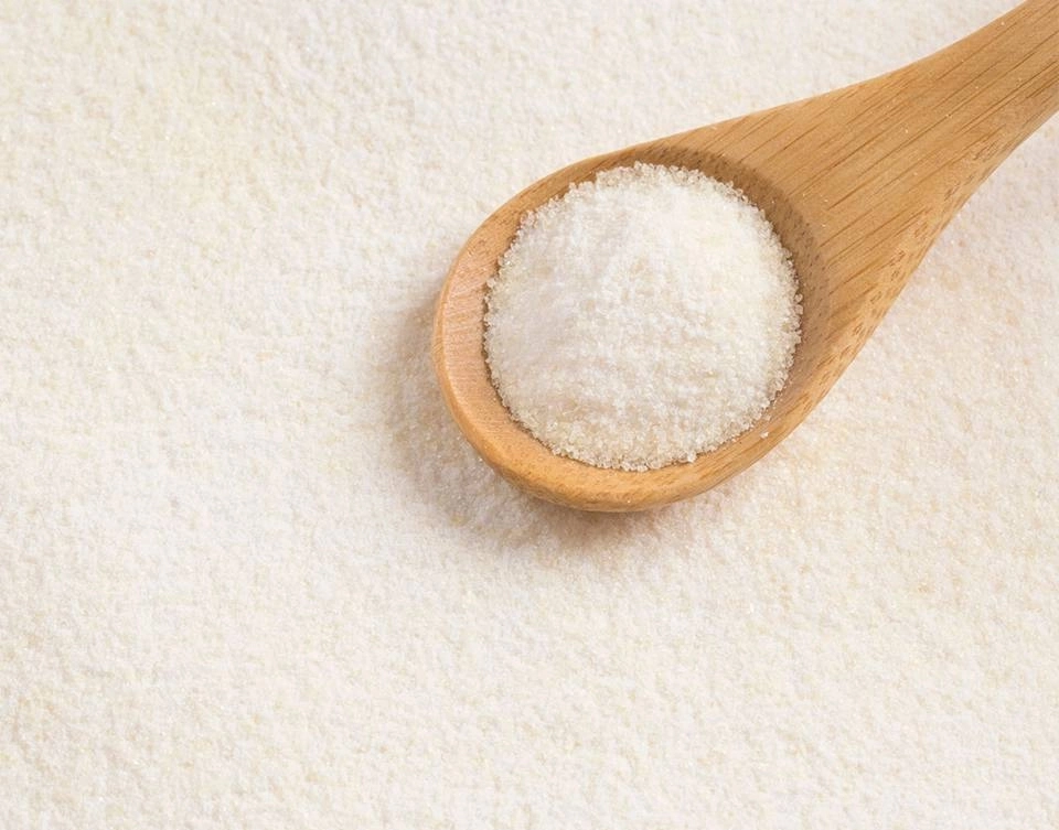 Growth Supplements - IMAGEM ILUSTRATIVA COLHER COM COLÁGENO HIDROLISADO EM UM FUNDO CHEIO DE AÇUCAR