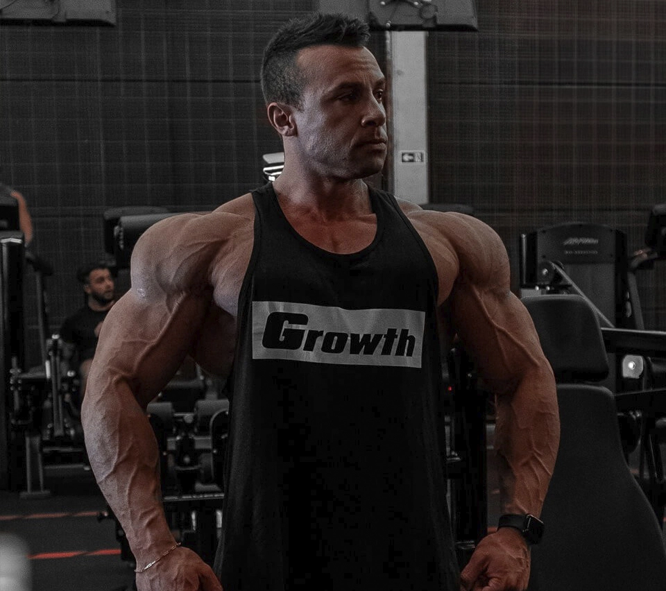 Diogo Montenegro - Atleta Growth Supplements de regata na academia mostrando os musculos