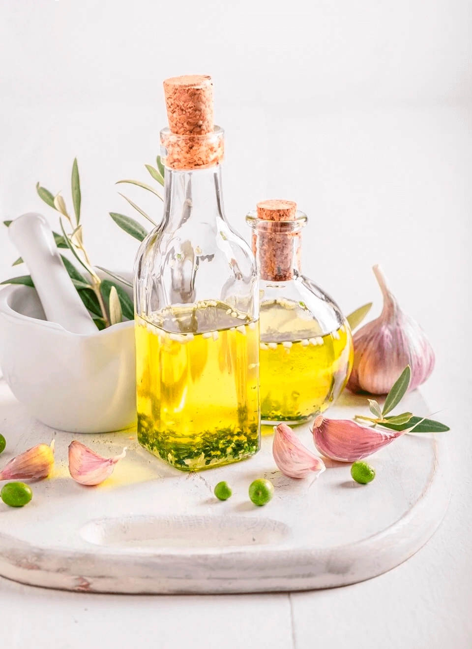 GROWTH SUPPLEMENTS - Garrafas de vidro com óleo de alho com pilão, e cabeça e dentes de alho ao seu redor