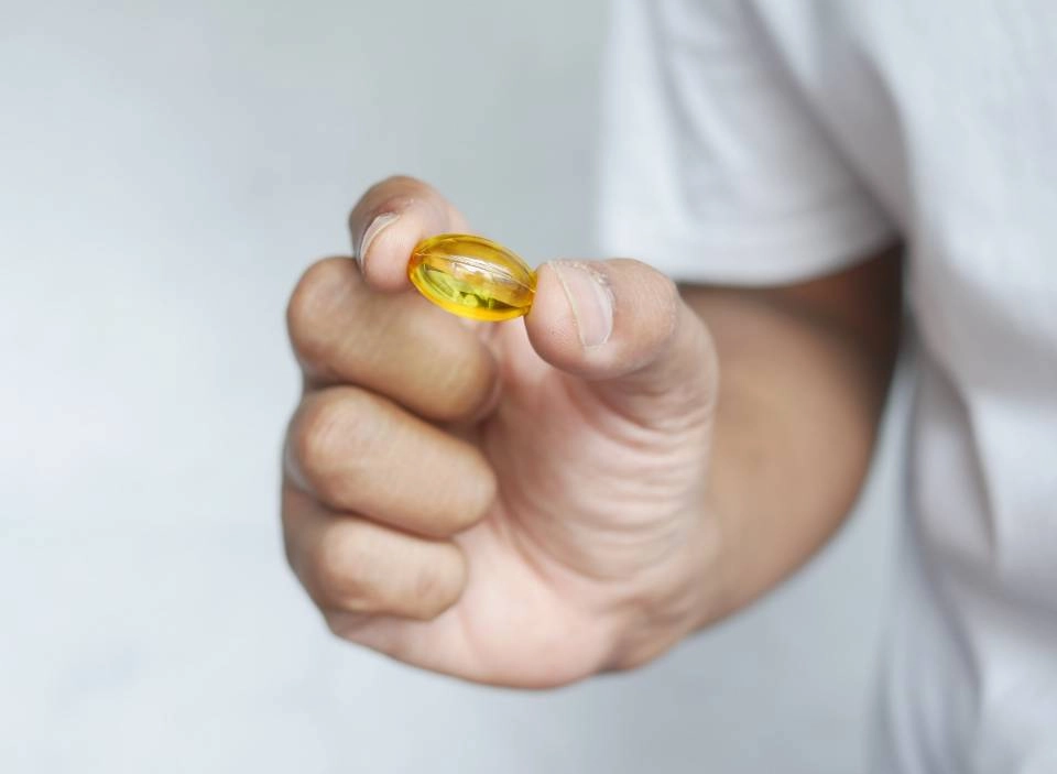 GROWTH SUPPLEMENTS - Homem segurando comprimido de óleo de peixe