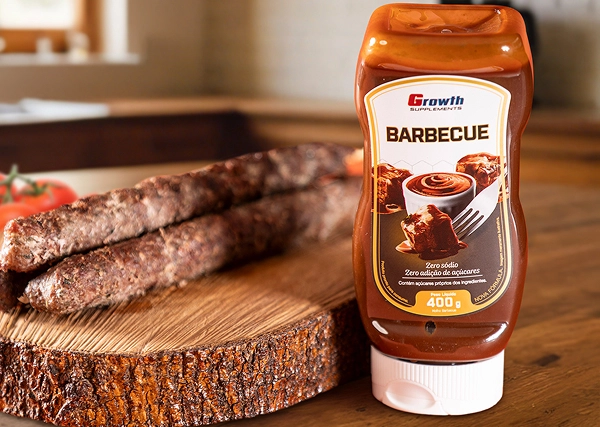Molho barbecue Growth Supplements 400g ao lado de uma tábua de churrasco