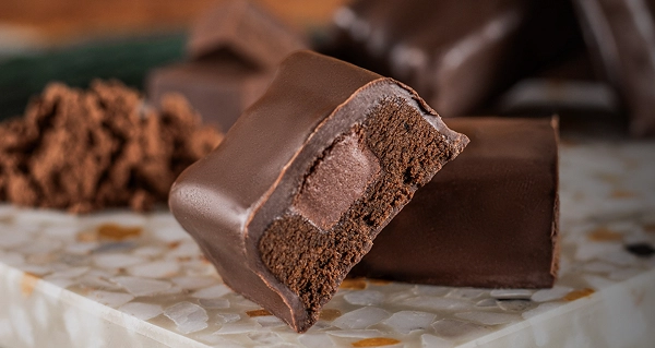 Barra de proteína vegana cortada ao meio em cima de uma tábua