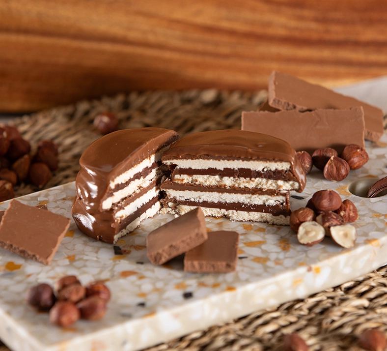 Alfajor com Whey Protein sabor chocolate cortado ao meio em cima de uma tábua