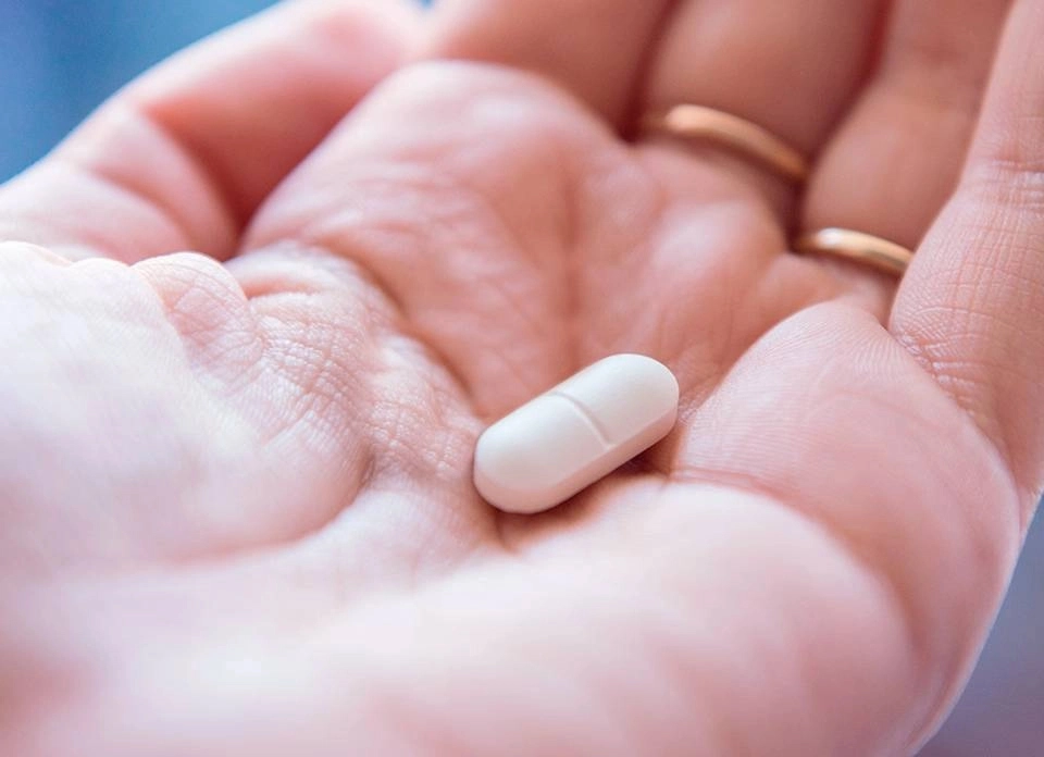 GROWTH SUPPLEMENTS - Mão segurando comprimido