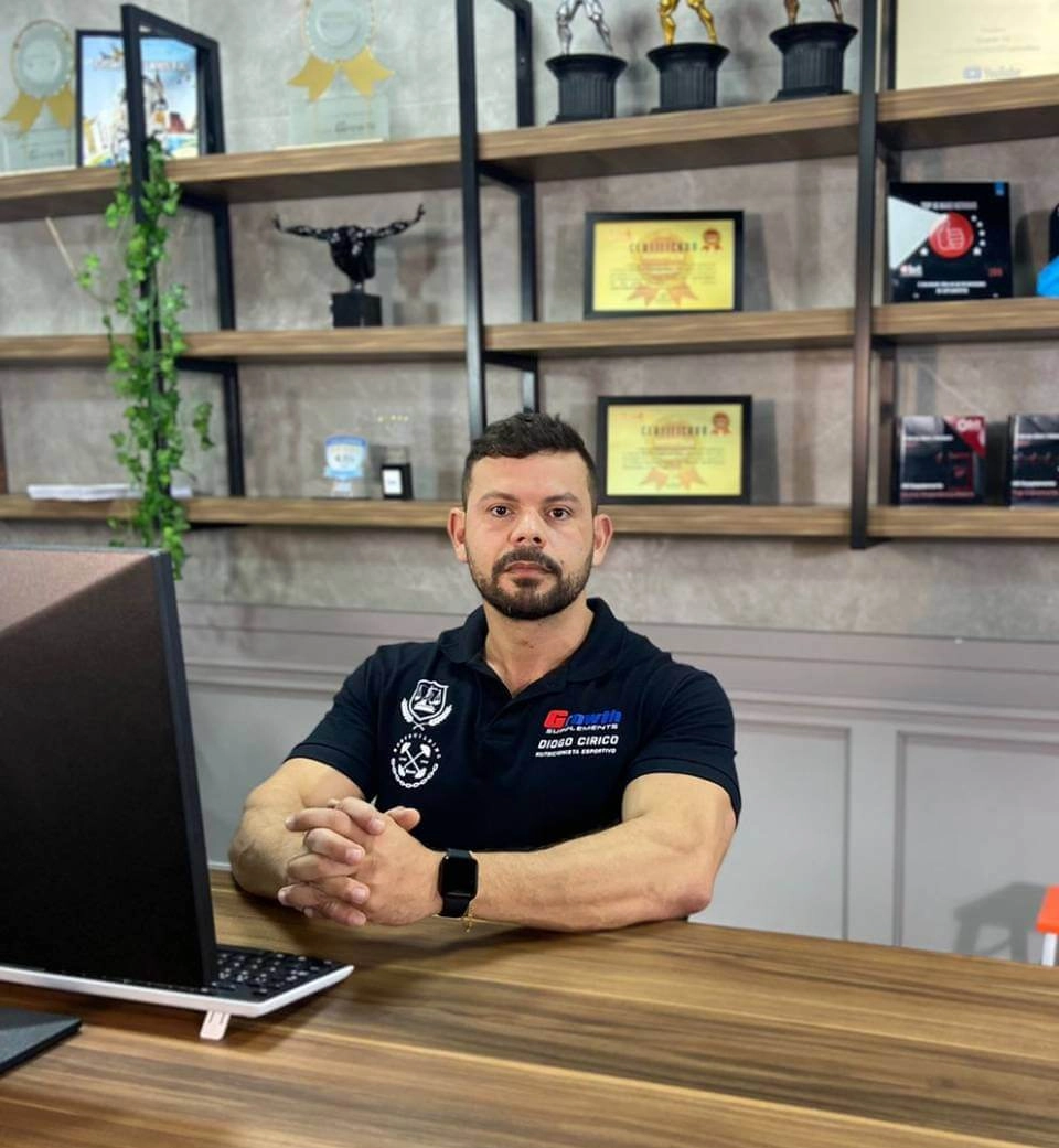 Diogo Círico- Nutricionista Growth Supplements, sentado na cadeira com o notebook em cima da mesa