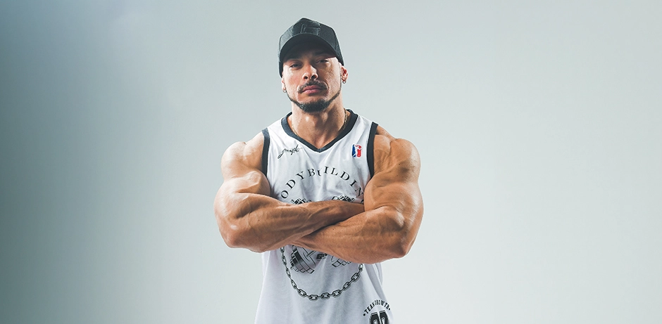 Felipe Franco - Atleta Growth Supplements, de regata e boné mostrando os músculos
